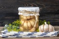 Homemade pickled garlic, dill in jars on wooden shelf Homemade canned and fermented foods concept Seasonal product Royalty Free Stock Photo