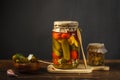 Homemade pickled, fermented vegetables and mushrooms in glass jars with herbs and garlic. On a dark rustic wooden table Royalty Free Stock Photo