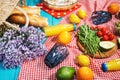 Homemade picnic with fresh fruits, vegetables, salad, orange juice, flowers and baguette on a red plaid. Beautiful still life