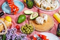 Homemade picnic with fresh fruits, vegetables, salad, orange juice, flowers and baguette on a red plaid