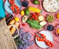 Homemade picnic with fresh fruits, vegetables, salad, orange juice, flowers and baguette on a red plaid. Beautiful still life