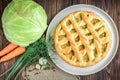 Homemade pie with cabbage, carrot, onion and meat on wooden background Royalty Free Stock Photo