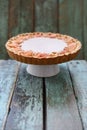 Homemade pie with cream filling and apple roses on stand on wood Royalty Free Stock Photo