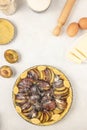 Homemade pie with plums and sugar placed on the white  background. Tart with raw plums. Top view, flat lay. Royalty Free Stock Photo