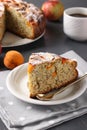 Homemade pie with poppy seeds, apricots and apples with a cup of coffee on a gray background. Vertical arrangement Royalty Free Stock Photo