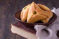 Homemade pies with potatoes and onions in a ceramic bowl on old cookbook Royalty Free Stock Photo