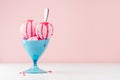 Homemade pink ice cream scoops in blue ice-cream bowl with strawberry jam, spoon in modern pink interior on white wood board. Royalty Free Stock Photo