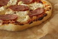 Homemade pizza with ham and cheese lies on parchment close-up view super on the side. Homemade fast food background Royalty Free Stock Photo