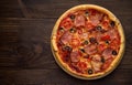 Homemade pizza with ham, cheese, tomatoes, olives on vintage wooden background. Royalty Free Stock Photo