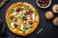 Homemade Pizza with salami sausage, cheese, mushrooms, black olives, tomato sauce and arugula, black table background, top view Royalty Free Stock Photo