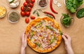 Homemade pizza. Woman adding rocket salad to pizza Royalty Free Stock Photo