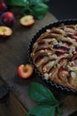 Homemade plum pie on a wooden background. Rustic style