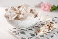 Homemade eggs dessert meringue on a plate on a light background. Next to pink flower and pieces of cookies. Copy space Royalty Free Stock Photo