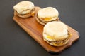Homemade pork roll egg sandwich on a rustic wooden board on a black background, low angle view. Close-up Royalty Free Stock Photo