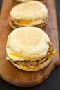Homemade pork roll egg sandwich on a rustic wooden board on a black surface, side view. Closeup Royalty Free Stock Photo