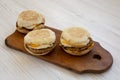 Homemade pork roll egg sandwich on a rustic wooden board on a white wooden background, low angle view. Closeup Royalty Free Stock Photo
