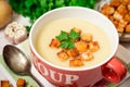 Homemade potato cream soup with croutons and parsley in red bowl on table Royalty Free Stock Photo
