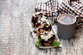 Homemade profiteroles with almonds and cup of coffee on wooden