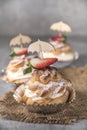 Homemade profiteroles with cream, strawberries and mint. Dessert for gourmets Royalty Free Stock Photo