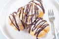 Homemade profiteroles with whipped cream and chocolate filling, closeup, horizontal