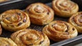 Homemade puff pastry cinnamon rolls with raisins placed on oven iron tray