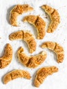 Homemade puff pastry croissants with walnut and brown sugar filling on a light background, top view