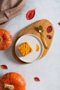 Homemade pumpkin cheesecake pie recipe with cinnamon on white table with pumpkins and autumn leaves on the background. Halloween Royalty Free Stock Photo