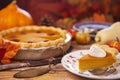 Homemade pumpkin pie on a rustic table with autumn decorations