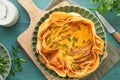 Homemade quiche or tart with slices of bacon and leeks with tortilla instead of dough on wooden cutting board on rustic old wooden