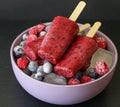 Homemade raspberries blueberries ice cream popsicles on dark background. Royalty Free Stock Photo