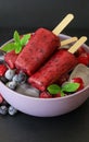 Homemade raspberries blueberries ice cream popsicles on dark background. Royalty Free Stock Photo