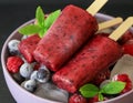 Homemade raspberries blueberries ice cream popsicles on dark background. Royalty Free Stock Photo