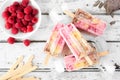 Raspberry, chocolate, banana yogurt ice pops, above view table scene on white wood Royalty Free Stock Photo