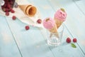 Homemade raspberry ice cream in waffle cones on rustic wooden ba Royalty Free Stock Photo