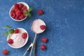 Homemade raspberry ice cream in a white cup on a blue background. Stainless steel spoon for ice cream balls. Fresh raspberries Royalty Free Stock Photo