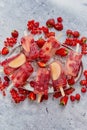 Homemade raspberry, strawberry, apple and currant popsicles on metal plate with ice assorted berries