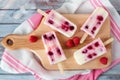 Homemade raspberry vanilla ice pops on a paddle board