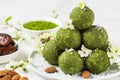 Homemade raw energy balls made of green matcha tea, dates and nuts with spring flowers. Healthy vegan dessert food Royalty Free Stock Photo