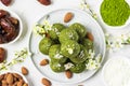 Homemade raw energy balls made of green matcha tea, dates and nuts with spring flowers. Top view. Food styling Royalty Free Stock Photo