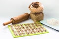 Homemade raw farfalle pasta on cutting board, rolling pin, craftpaper bag of flour and kitchen scale. Pasta of whole grain flour Royalty Free Stock Photo