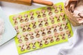 Homemade raw farfalle pasta on cutting board, rolling pin, craftpaper bag of flour and kitchen scale. Pasta of whole grain flour