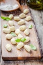 Homemade raw gnocchi with flour and basil Royalty Free Stock Photo