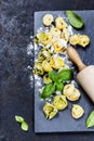 Homemade raw Italian tortellini and basil leaves