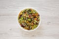 Homemade Raw Shredded Broccoli Slaw in a white bowl on a white wooden background, top view. Overhead, from above, flat lay Royalty Free Stock Photo