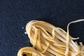 homemade raw uncooked pasta fettuccine, tagliatelle, spaghetti on working table. Raw fresh handmade pasta, italian food at home