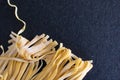 homemade raw uncooked pasta fettuccine, tagliatelle, spaghetti on working table. Raw fresh handmade pasta, italian food at home