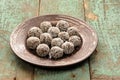 Homemade raw vegan sweets in coconut shavings in ceramic plate o