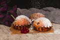 Homemade red currant muffins with sesame seeds on brown baking paper. Falling icing sugar on baked muffins. Closeup Royalty Free Stock Photo