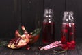 Homemade red pomegranate lemonade in small glass bottles