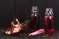 Homemade red pomegranate lemonade in small glass bottles